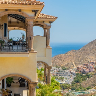 Mediterranean-style villa showcasing elegant stone architecture with scenic mountain and coastal views of the surrounding area.
