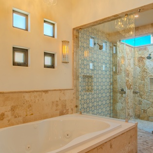 Soak in your private spa-like bathroom with a luxurious jetted tub and stunning walk-in shower featuring elegant tilework and natural light.