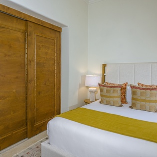 Sink into crisp linens and plush pillows in your serene bedroom, where warm wood tones and thoughtful touches create the perfect retreat.