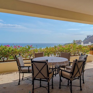 Savor morning coffee at your private terrace, where vibrant blooms frame sweeping ocean views and coastal mountains create a stunning backdrop for relaxation.
