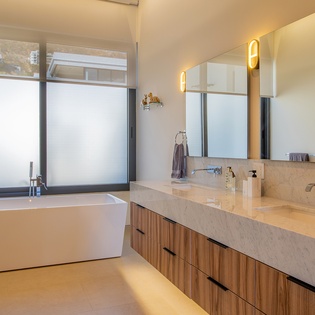Unwind in your spa-like bathroom with marble countertops, soaking tub, and dual vanities bathed in warm natural light.