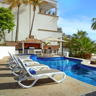 Dive into your private oasis with pristine pool, BBQ pavilion, and lounge chairs surrounded by swaying palms.