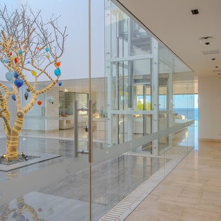 Step into a stunning modern space where art meets elegance - featuring polished floors, soaring ceilings, and a striking decorative tree centerpiece.