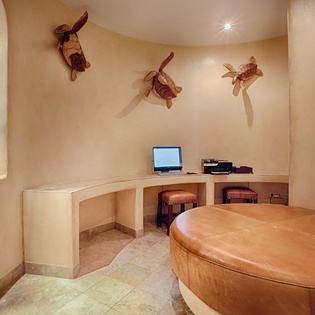 Your cozy work nook features warm earthy tones, built-in desk space, and charming carved sea turtle wall art that brings coastal character to your workspace.