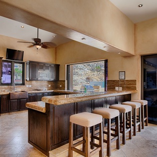 Picture yourself preparing meals at this spacious island, where granite countertops and dark wood cabinetry create a warm, inviting space. Natural light pours in through large windows while you cook, and the patio beckons just steps away for alfresco dinin