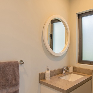 Fresh linens await in your private bathroom, where morning routines feel effortless with elegant stone counters and natural light.