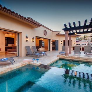 Mediterranean-style villa featuring a private pool, covered outdoor lounge with dining area, and multiple sunbeds—your serene retreat for warm-weather relaxation.