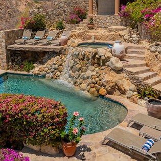 Stone patio with sun deck and pool