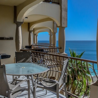 Sunny balcony with outdoor seating and ocean views