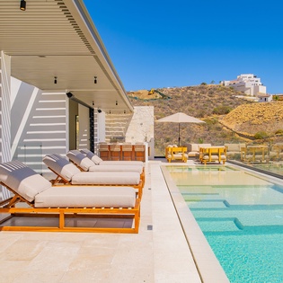 Unwind on plush poolside loungers while soaking up Mediterranean sunshine and breathtaking hillside views from your private terrace oasis.