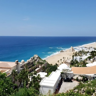 Stunning coastal resort community with pristine beach, turquoise waters, and distinctive rock formations creating an idyllic seaside setting.