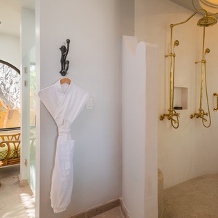 En suite bathroom with walk in shower and bath robes