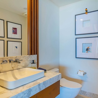 Step into your private bathroom with sleek marble vanity, modern vessel sink, and charming framed art that adds personality to your morning routine.