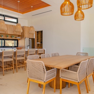 Gather around the stunning dining table where warm wood tones and woven textures create your perfect space for memorable meals together.