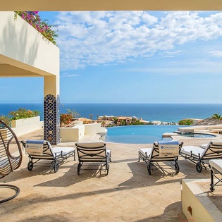 Spectacular sea views frame your private terrace, where hanging chairs and plush loungers invite you to soak up the coastal breeze beside the sparkling infinity pool.