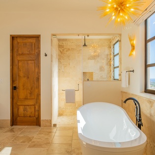 Soak in your luxurious standalone tub while golden light dances overhead and city views stretch beyond your windows.