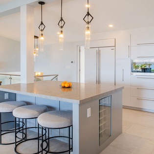 Step into your sleek, modern kitchen where pendant lights illuminate the spacious island—perfect for morning coffee or evening conversations.