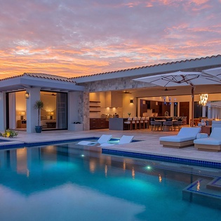 Stunning sunset views frame this luxurious property, where your private pool beckons under painted skies. Sink into poolside loungers as twilight hues dance across the water, casting a warm glow over your open-air retreat.