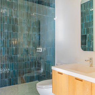 Step into your spa-like bathroom featuring stunning turquoise tiles and a luxurious rainfall shower that will refresh you after long days exploring.