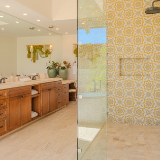 Refresh in your stunning bathroom featuring vibrant patterned tile, spacious walk-in shower, and elegant double vanity with ample storage.