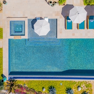 Stunning aerial view of the expansive resort pool surrounded by tropical gardens and comfortable lounge areas.