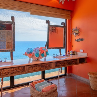 En suite bathroom with double sinks and ocean views