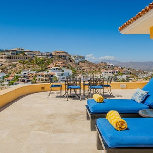 Unwind on your private terrace with stunning panoramic views. Sink into plush blue loungers and savor morning coffee while gazing at the hillside vista.