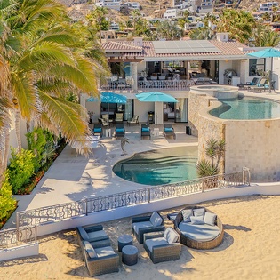 Spectacular hillside villa with multiple pools and terraces set against a scenic coastal backdrop, offering luxurious indoor-outdoor living spaces throughout the property.
