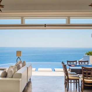 Living room and dining room with patio access and ocean view