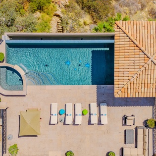 Aerial view of the property showcasing the swimming pool and outdoor terrace surrounded by natural landscape.