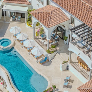 Aerial view of villa complex with swimming pool, terrace spaces, and Mediterranean-style red tile roofing.