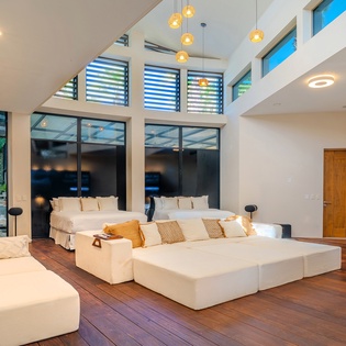 Unwind in this stunning open-concept bedroom where modern luxury meets comfort, featuring soaring ceilings and abundant natural light.