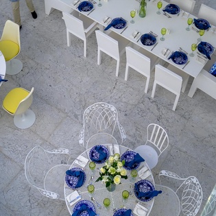 Dine al fresco in your elegant outdoor space, beautifully set with blue accents and fresh flowers for memorable meals.