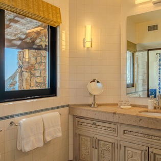 Your elegant marble bathroom offers ocean views while you refresh, featuring luxury finishes and Mediterranean charm.