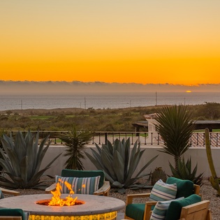 Stunning ocean sunset creates the perfect backdrop for your evening relaxation around the fire pit with desert landscaping.
