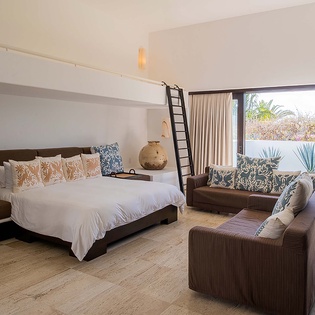 Sink into crisp white linens and wake to tropical breezes flowing through your private terrace, where lush palms and garden views invite you to start your day in paradise.