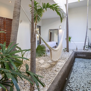 Your private tropical oasis awaits with a serene water feature and hammock perfect for afternoon relaxation.