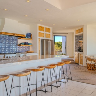 Your dream kitchen awaits with sleek counters, stylish bar seating, and warm wood accents creating the perfect space for cooking and gathering.