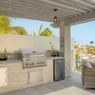 Your private outdoor kitchen features a premium grill and tropical ocean views for unforgettable sunset dinners.
