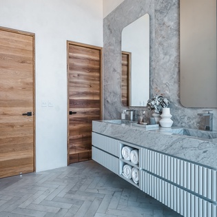 Indulge in your luxurious marble bathroom, where modern elegance meets comfort with stunning floating vanities and soft towels awaiting your arrival.