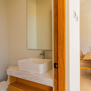 Refresh in your modern bathroom featuring a sleek vessel sink and marble countertop, with warm wood accents creating a spa-like atmosphere.