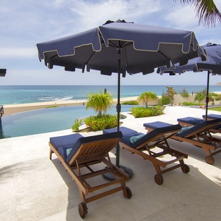 Lounge poolside with a beachfront view