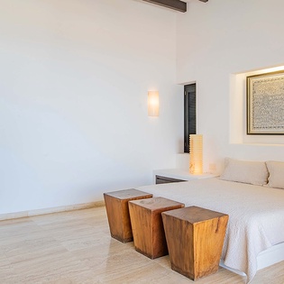 Sink into the soft linens and natural warmth of your spacious bedroom, where rustic wooden accents and soft lighting create a serene escape just for you.