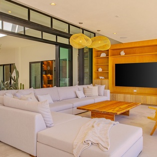 Settle into this stunning living room where modern elegance meets comfort. The plush sectional and warm wood entertainment center create your perfect gathering space.