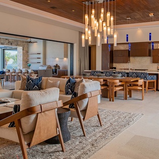 Luxurious open-concept living with warm wood accents and designer lighting. Relax, dine, and cook while enjoying palm tree views.