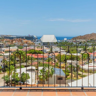 Sweeping coastal views stretch from your private balcony, framing palm-lined streets, distant mountains, and the sparkling sea beyond—a stunning backdrop for morning coffee or sunset relaxation.