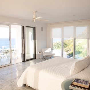 Wake up to stunning sea views in your bright bedroom with floor-to-ceiling windows and private terrace access.