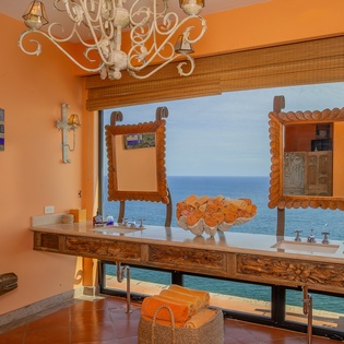 En suite bathroom with double sinks and ocean views