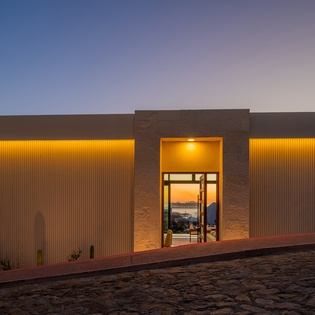 Modern architectural design with warm lighting creates a striking first impression at this contemporary property entrance.