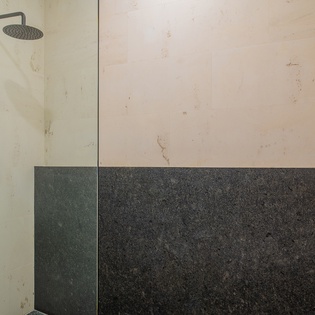 Indulge in your private spa-like shower with sleek marble walls and rainfall showerhead for pure relaxation.